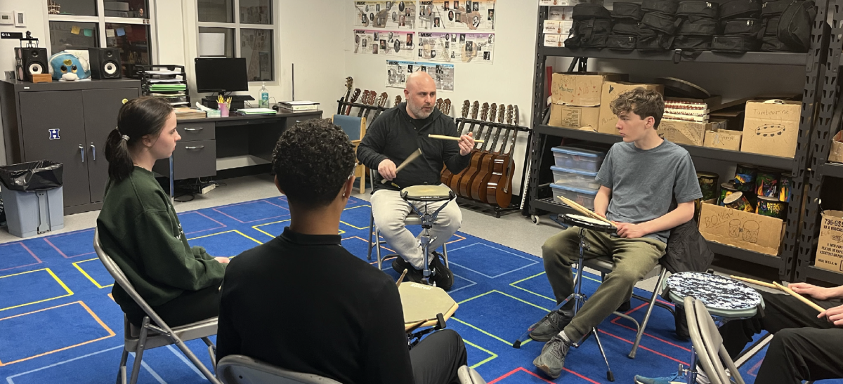 Senior Keira Shanahan and freshmen Kaiser-Sose Toribio and Eli Hudson welcome Simon Boyar, a guest musician, on April 24, 2025.